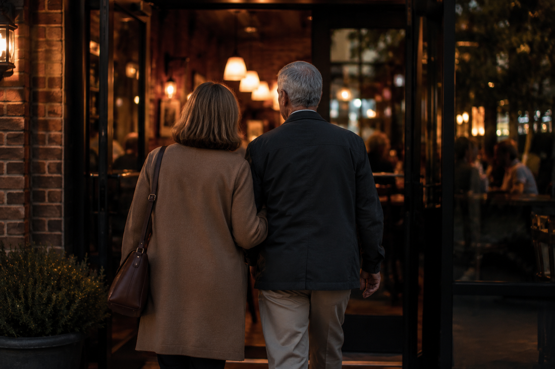 A couple walking into a restaurant together in the evening, illustrating the quiet act of resistance that going out becomes for caregiving families.