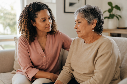 Caregiver sitting with a loved one experiencing pseudobulbar affect after brain injury, representing the emotional disconnect between internal feeling and outward expression in neurological conditions including TBI, CTE, stroke, and dementia.